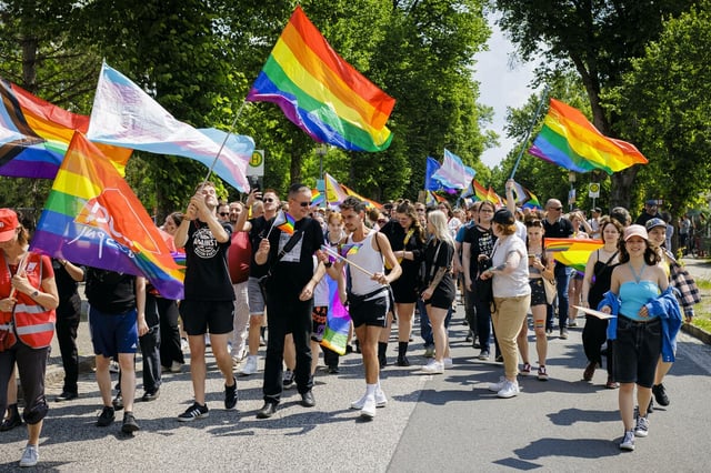 Menschen mit Regenbogenfahnen bei einer Demonstration.