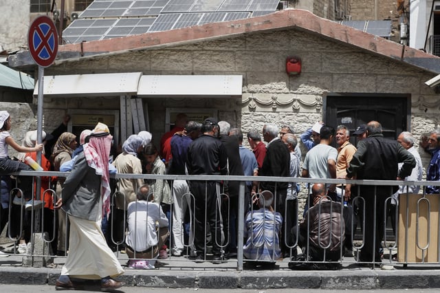Syrians line up to retrieve money from an ATM in Damascus, Syria, Wednesday, May 14, 2025. (AP Photo/Omar Sanadiki)