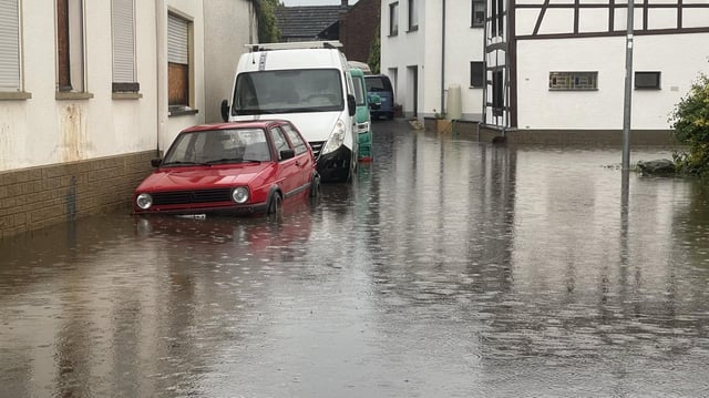 Eine Straße in Euskirchen steht nach Starkregen unter Wasser.