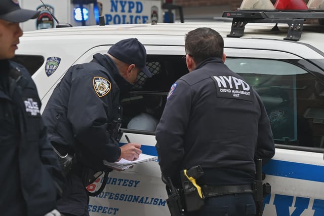 NYPD officers take someone into custody in Queens on April 27, 2025.