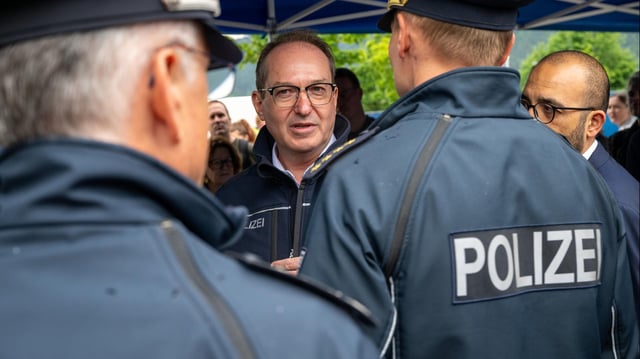Alexander Dobrindt unterhält sich bei seinem Besuch an einer Grenzkontrollstelle mit Polizeibeamten.
