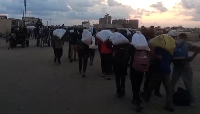 Palestinians carry aid supplies which they received from the U.S.-backed Gaza Humanitarian Foundation, in Rafah, in the southern Gaza Strip, June 3, 2025, in this screengrab taken from video. Reuters TV via REUTERS