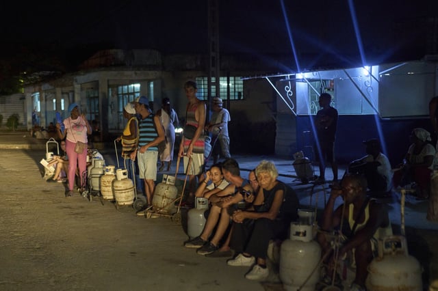 People wait to refill their cooking gas canisters in Alamar, Havana province, Cuba, late Saturday, May 31, 2025. (AP Photo/Ramon Espinosa)