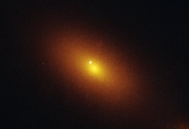 This is a Hubble Space Telescope image of a galaxy located 600 million light-years away that is host to a roaming supermassive black hole. Visible in the Hubble image is a tidal disruption event, an intense flash of radiation caused by the supermassive black hole eating a star.