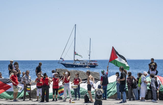 CATANIA, ITALY - JUNE 01: On the quay of San Giovanni Li Cuti, a group of activists attend the departure of the Madleen for Gaza with songs and Palestinian flags on June 01, 2025 in Catania, Italy. Swedish activist Greta Thunberg is among those who will attempt to sail to Gaza on a boat organized by the Freedom Flotilla Coalition (FFC), in a bid to break Israel's blockade of the Palestinian territory. Freedom Flotilla had to abort a previous journey in early May after it said its boat came under attack by drones in international waters near Malta. (Photo by Fabrizio Villa/Getty Images)