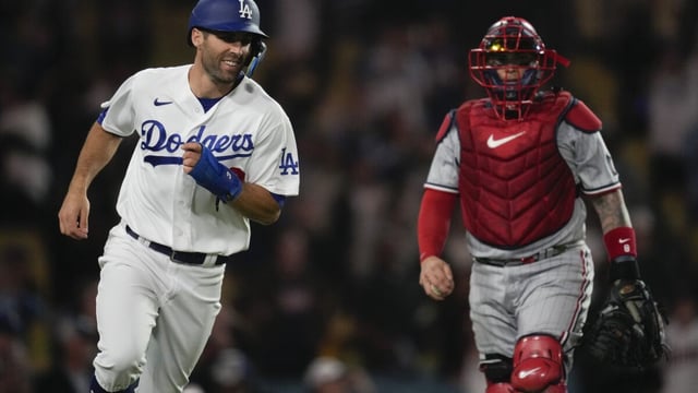 Los Angeles Dodgers' Chris Taylor, left, reacts after scoring during the twelfth inning of a baseball game against the Minnesota Twins in Los Angeles, Monday, May 15, 2023. The Dodgers won 9-8 in the 12th inning. (AP Photo/Ashley Landis)