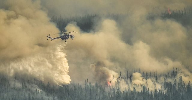 A Sky crane helicopter dumps water on the Eagle Wildfire Complex near Fox Creek, Alberta, Canada May 19, 2023. Alberta Wildfire/Handout via REUTERS   