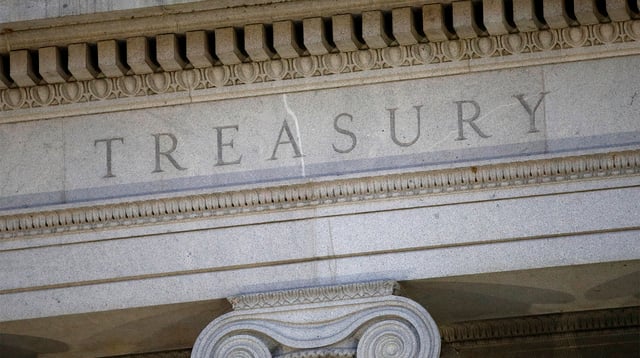 FILE- The U.S. Treasury Department building is shown at dusk in Washington on June 6, 2019. The U.S. has imposed new sanctions on alleged violators of the price cap on Russian oil and tightened compliance rules for insurance firms and shippers that move Russian oil. Firms from the United Arab Emirates and Hong Kong have been identified for economic sanctions.