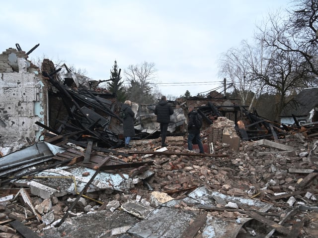 People stand among the debris of the destroyed Shukhevych Museum after a drone attack in Bilogorshchethe, on the outskirt of Lviv on January 1, 2024, amid the Russian invasion of Ukraine. The museum was named after UPA Corporal General Roman Shukhevych (19071950), the leader of the Ukrainian Insurgent Army. Andriy Sadovy, Mayor of Lviv said in his post in social media that the Shukhevych Museum in Bilogorshche was completely destroyed. Several private buildings were also damaged in Bilogorshche - windows and doors were blown out. (Photo by YURIY DYACHYSHYN / AFP) (Photo by YURIY DYACHYSHYN/AFP via Getty Images)