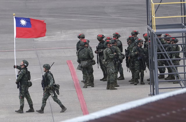 A soldier holds up Taiwan's flag during military exercises on the island. (Photo via AP/Chiang Ying-ying)