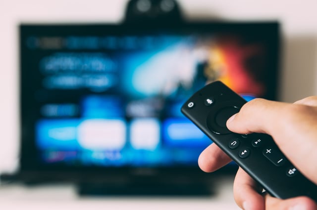 A person with a firestick remote watches Amazon Prime Video
