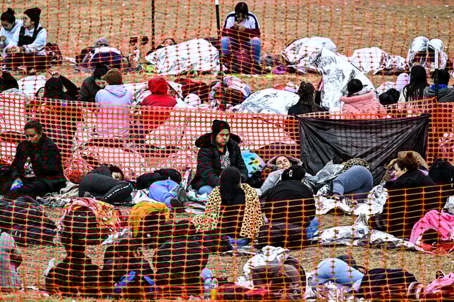 Immigrants wait to be processed at a US Border Patrol transit center after they crossed the border from Mexico in Eagle Pass, Texas, on December 22, 2023.