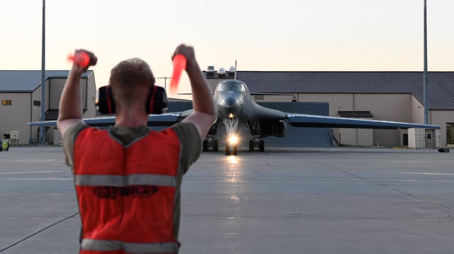 U.S. Air Force airmen directs a B-1B Lancer onto the runway during a Bomber Task Force (BTF) mission at Ellsworth Air Force Base, S.D.