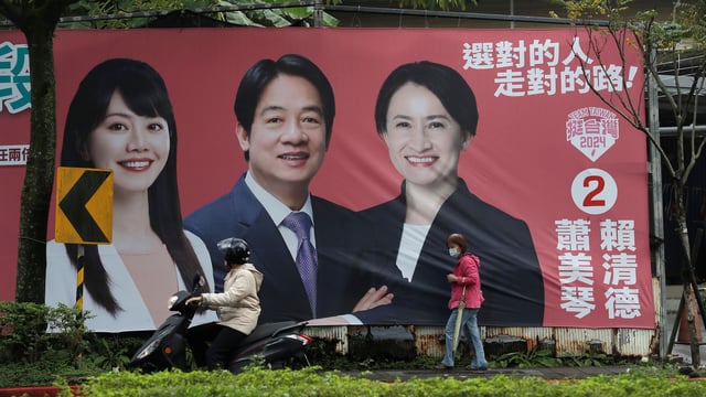 People pass by a campaign poster for Taiwan’s presidential election, in Taipei, Taiwan, Dec. 28, 2023 (AP photo by Chiang Ying-ying)