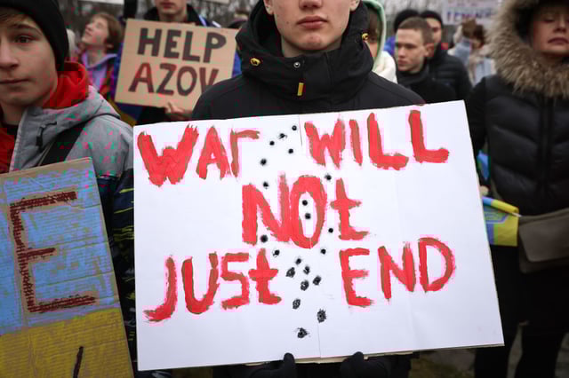 A protester holds a banner reading "War Will Not Just End" as activists from the German-Ukrainian group Vitsche protest outside the Chancellery to demand increased military support from Germany to Ukraine on January 6, 2024 in Berlin, Germany. Among their demands is the delivery of German Taurus long-range cruise missiles, which Chancellor Scholz has so far denied. 