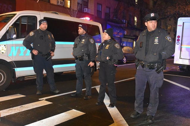 Police officers stand guard on a road after an assailant attacked three NYPD officers with a machete during the new year celebrations in New York on December 31, 2022.