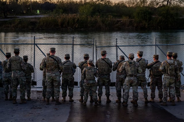 National Guard soldiers stand guard Friday on the banks of the Rio Grande at Shelby Park in Eagle Pass, Texas.