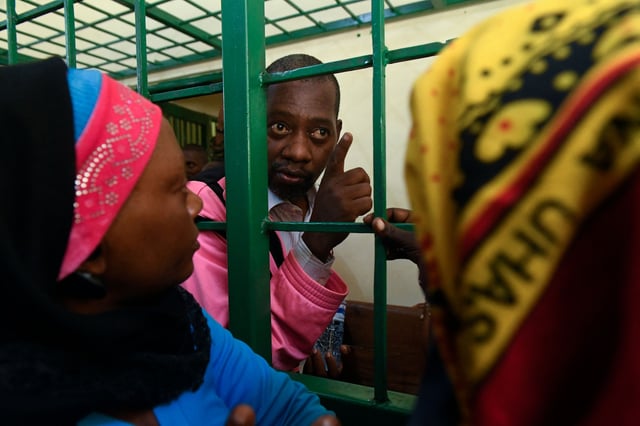 Self-proclaimed pastor Paul Nthenge Mackenzie (C), who set up the Good News International Church in 2003 and is accused of inciting cult followers to starve to death "to meet Jesus", talks to his relatives.