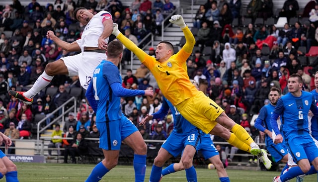 Slovenia goalkeeper Igor Vekic (1) and Klemen Mihelak defend a cross as United States' Miles Robinson (12) tries for a header during the first half of an international friendly soccer match in San Antonio, Saturday, Jan. 20, 2024. (AP Photo/Eric Gay)