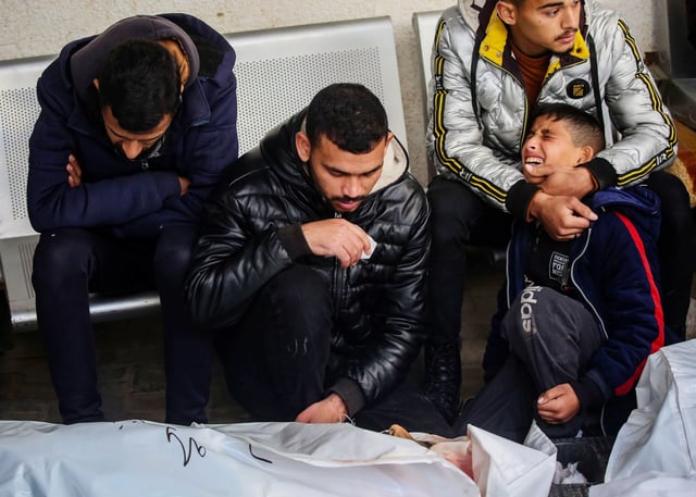 RAFAH, GAZA - JANUARY 21: (EDITOR'S NOTE: Image depicts death) People mourn as they collect the bodies of friends and relatives killed in an airstrike, on January 21, 2024 in Rafah, Gaza. Israel increased air raids in the south of the Gaza Strip, where medicines are expected for hostages held by Hamas and humanitarian aid for the Palestinian population. Despite Israel's recent troop drawdown in Gaza and the discussion of postwar plans by an Israeli cabinet minister, the country has continued its intensive bombardment of the Gaza Strip, particularly in the territory's south, as it seeks to destroy Hamas, the Palestinian militant group behind the Oct. 7 attacks. More than 24,000 people have been killed in Gaza in the last three months, according to the territory's health ministry, and most of the population has been displaced. (Photo by Ahmad Hasaballah/Getty Images)