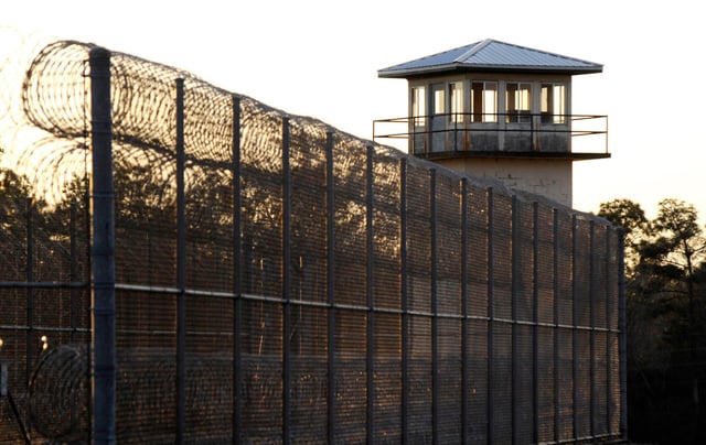 The sun sets behind Holman Prison in Atmore, Ala., on Thursday, Jan., 27, 2022, as the U.S. Supreme Court considered whether to allow the execution of death row inmate Matthew Reeves, convicted of killing a man during a robbery in 1996. (AP Photo/Jay Reeves)