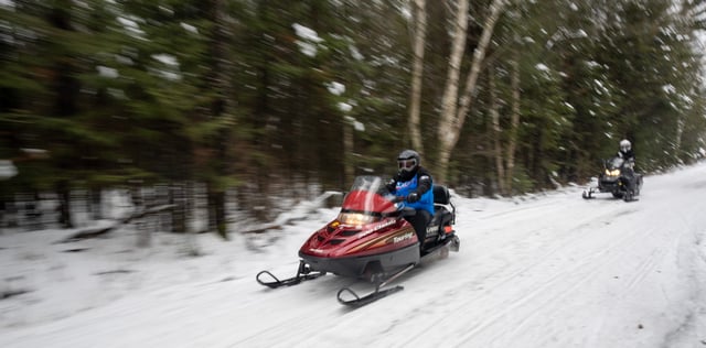 Snowmobilers ride a trail Thursday, December 29, 2022 in the Pelican River Forest between Rhinelander and Crandon, Wis. It is bisected by Highway 8 east of Rhinelander and straddles the Great Lakes and Mississippi River watersheds.In October, the Wisconsin Natural Resources Board signed off on a $15.5 million conservation easement for more than 56,000 acres in northern Wisconsin.It is the largest land conservation effort in state history.  It will secure permanent access for public recreation, continue timber management and keep the tract free from development.