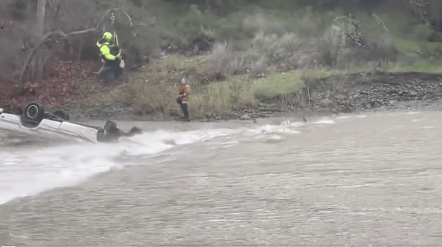 A screenshot of a video taken by law enforcement shows a California Highway Patrol helicopter rescuing a woman trapped in Del Valle Creek overnight.