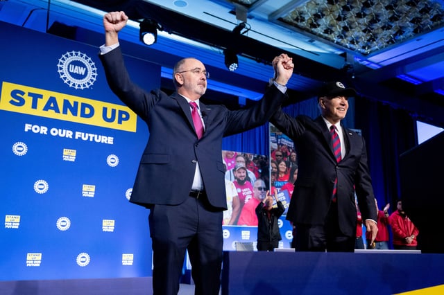  President Joe Biden and Shawn Fain, President of the United Auto Workers (UAW), wave during the United Auto Workers union conference at the Marriott Marquis, in Washington, DC, on January 24, 2024.  