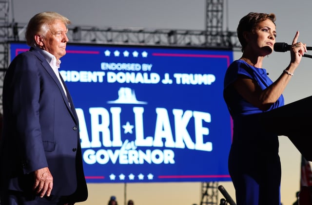 Former U.S. President Donald Trump (L) looks on as Arizona Republican nominee for governor Kari Lake speaks during a campaign rally attended by former U.S. President Donald Trump at Legacy Sports USA on October 09, 2022 in Mesa, Arizona