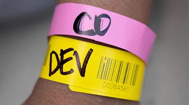 A migrant from Venezuela shows a wrist band indicating that they are traveling to Denver, Colorado.