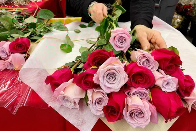 A woman arranges flowers on Valentines Day at Whole Foods Market in Annapolis, Md., on Feb. 14, 2023.