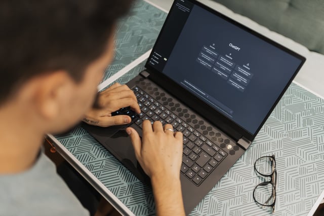 A man at a laptop is using OpenAI's popular generative AI, ChatGPT.