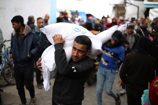 A man carries relief supplies provided by UNRWA in Rafah, southern Gaza, on January 28, 2024.
