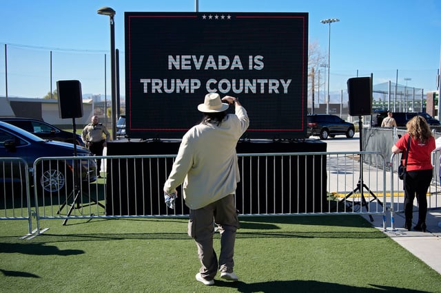 A person takes a picture of a screen before former President Donald Trump speaks at a campaign event in Las Vegas on January 27, 2024.