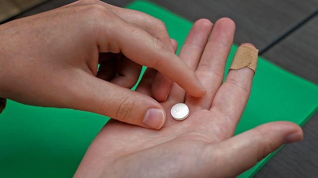 A patient prepares to take the first of two combination pills, mifepristone, for a medication abortion during a visit to a clinic in Kansas City, Kan., Oct. 12, 2022. On Monday, Oct. 30, 2023, a Kansas judge put a new state law on medication abortions on hold and blocked older restrictions that for years have spelled out what providers must tell patients and forced patients to wait 24 hours to end their pregnancies. (AP Photo/Charlie Riedel, File)