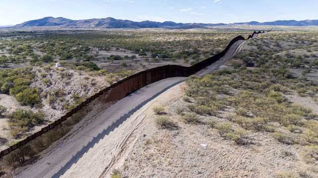 TOPSHOT - This aerial picture taken on December 8, 2023 shows the US-Mexico border wall in Sasabe, Arizona. Jaguars don't understand borders, but where the United States meets Mexico, they are having to adapt to them. Once the master of the plains of the Sonoran Desert, the animal is now struggling to survive in a landscape cut in two by a wall The barrier, which former US President Donald Trump boasted he would make "impenetrable" does little to discourage the thousands of people from Latin America, Asia, Africa and Eastern Europe who arrive every day. But, say conservationists, it is deadly to wildlife. (Photo by VALERIE MACON / AFP) (Photo by VALERIE MACON/AFP via Getty Images)