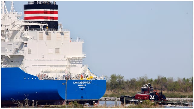 A tugboat helps guide a French ship, known as the LNG Endeavor, through Calcasieu Lake near Hackberry, La. The ship was on its way to the Cameron LNG export facility to pick up liquified natural gas.