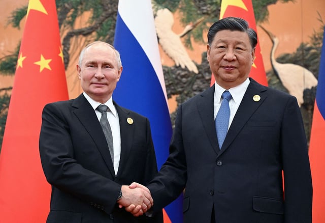 Russia's President Vladimir Putin and Chinese President Xi Jinping shake hands during a meeting in Beijing on October 18, 2023.