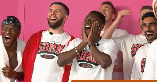 KSI, Josh, Tobi, Simon, Harry and Vik all stood in front of a pink background. They are all wearing SDMN merch and are laughing. There is an RT REVIEW orange badge in the right hadn't corner with 4 yellow stars shaded in