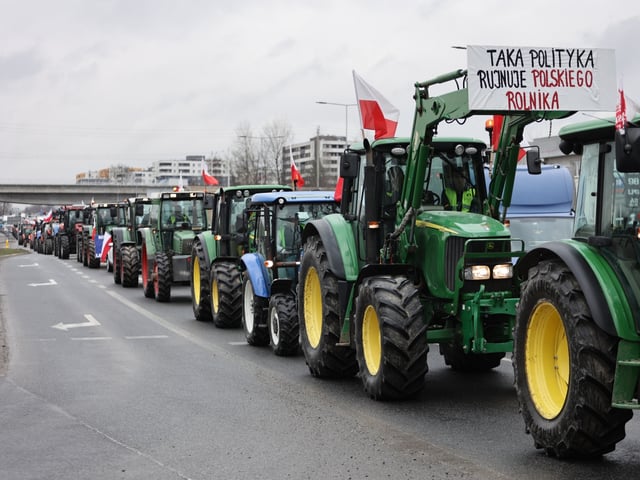 KRAKOW, POLAND - FEBRUARY 20: Farm tractors drive slowly to block the street in Krakow, Poland on February 20, 2024. Farmers in Poland decided again to block streets in the biggest cities, roads across the country, as well as Polish-Ukrainian border crossings in protest, mainly against imports of products from Ukraine and introduced European Green Deal regulations. (Photo by Jakub Porzycki/Anadolu via Getty Images)