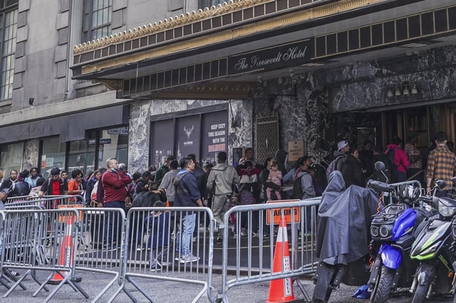 Asylum-seekers line up in front of the historic Roosevelt Hotel, converted into a city-run shelter for newly arrived migrant families in Manhattan on Sept. 27.