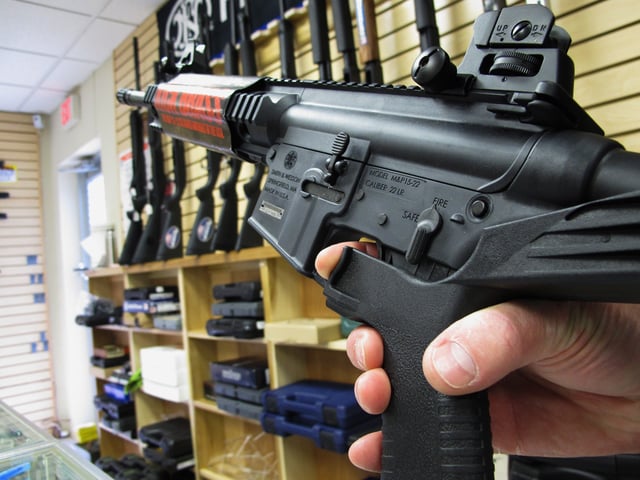 In this Feb. 1, 2013, file photo, an employee of North Raleigh Guns demonstrates how a "bump" stock works at the Raleigh, N.C., shop.