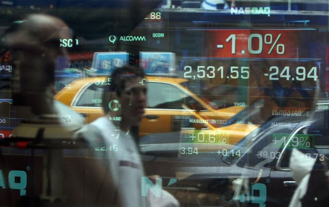 NEW YORK - AUGUST 10: Pedestrians are reflected in a window at the Nasdaq MarketSite as a ticker shows the Nasdaq Composite Index down one percent August 10, 2007 in New York City. Stocks were down after the Federal Reserve stated it would provide liquidity to "facilitate the orderly functioning of financial markets." (Photo by Mario Tama/Getty Images)