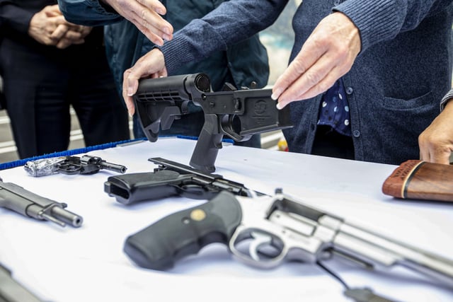 A bump stock and handguns collected during a buyback event in the Wilmington neighborhood of Los Angeles on March 4, 2023. 