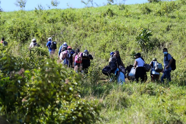 In this January 2022 photo, migrants wanting to reach the US, mostly Hondurans and Nicaraguans, cross from Honduras to Guatemala.