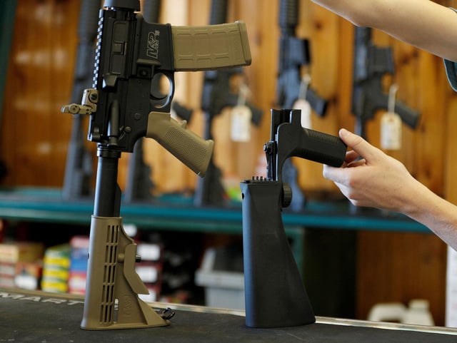 A bump fire stock, seen right, that attaches to a semi-automatic rifle to increase the firing rate is seen at Good Guys Gun Shop in Orem, Utah, in October 2017.