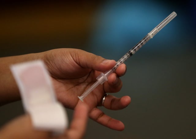 OAKLAND, CA - DECEMBER 19: A Walgreens employee holds a syringe during a free flu shot clinic at Allen Temple Baptist Church on December 19, 2014 in Oakland, California. Oakland residents received no cost flu shots during a flu shot clinic at Allen Temple Baptist Church. (Photo by Justin Sullivan/Getty Images)