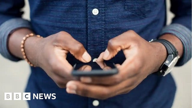 An anonymous man using his smartphone.