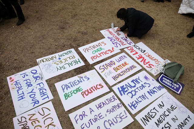 A doctor writes messages during a rally to protest against government plans to increase medical school admissions in Seoul on Sunday.