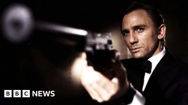 Daniel Craig as James Bond. He is seen wearing a tuxedo and pointing a gun off-screen.